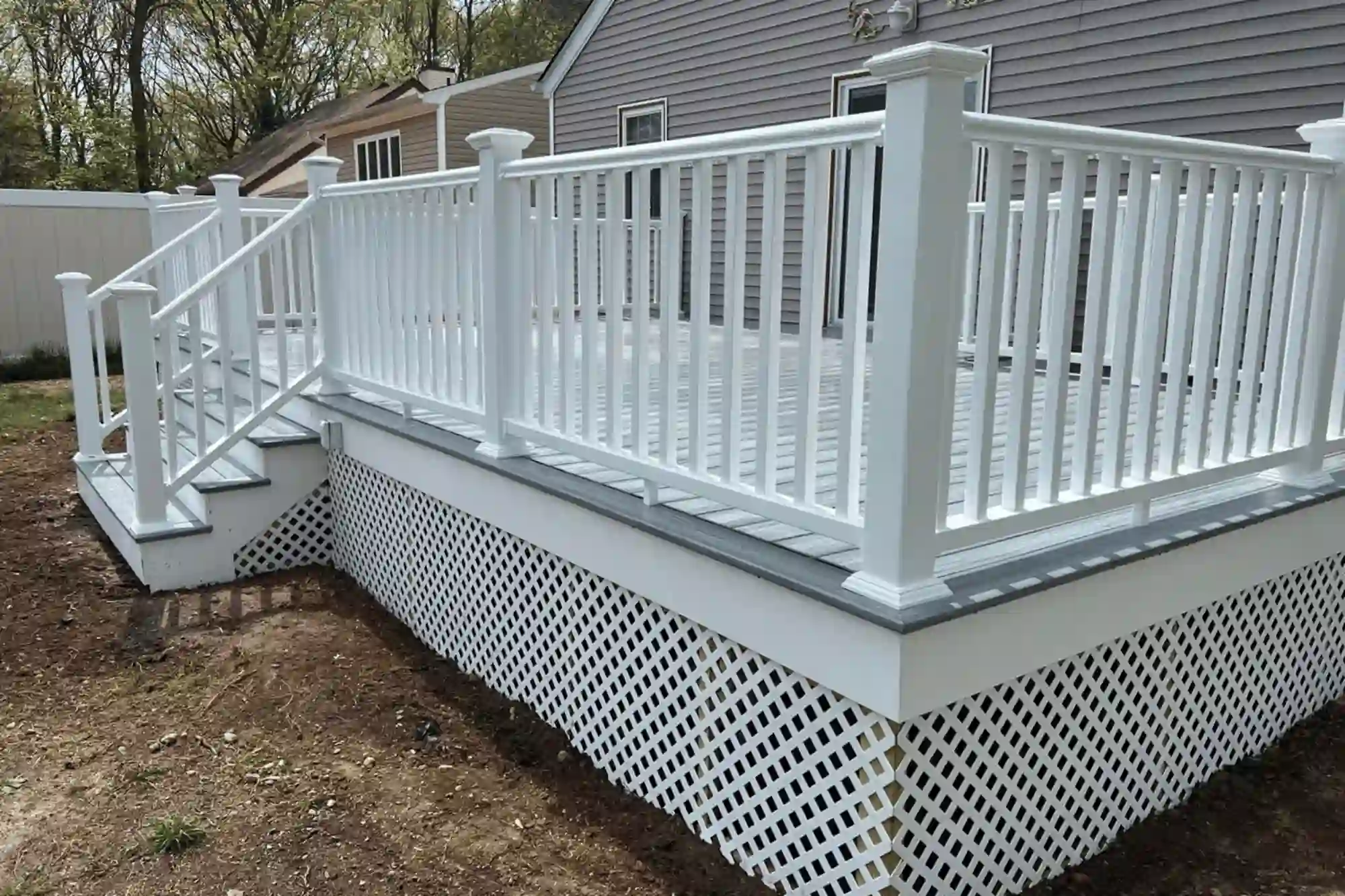 Completed custom deck with white railing in Huntington Station - built to enhance outdoor space.